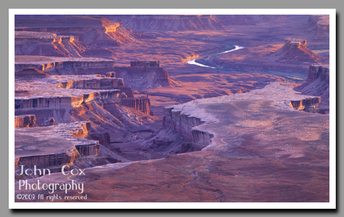 The Green River meanders through the brilliantly lit canyons below the Green River Overlook in Canyonlands National Park.