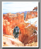 An arch frames the snow covered landscape surrounding Bryce Canyon National Park in Utah.