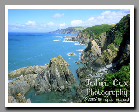 The ocean meets the green cliffs at Bull Point, outside of Devon, England.