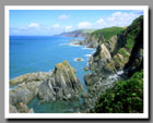 The ocean meets the green cliffs at Bull Point, outside of Devon, England.