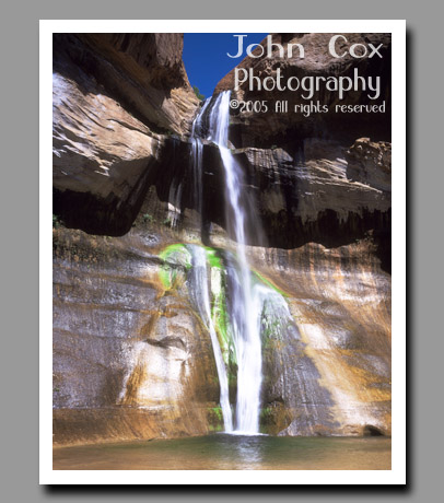 Water cascades down the colorful mossy walls of Lower Calf Creek Falls in grand Staircase-Escalante National Monument in Utah.