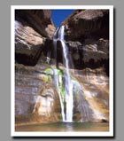 Water cascades down the colorful mossy walls of Lower Calf Creek Falls in grand Staircase-Escalante National Monument in Utah.