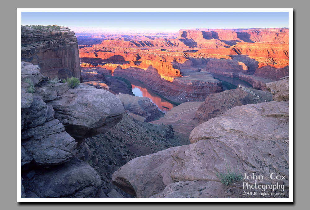 Goosenecks of the Colorado River bask in the light of a rising sun below Dead Horse Point in Utah.