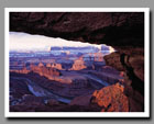 The Colorado River winds through a gooseneck beneath snow-covered cliffs from Dead Horse Point in Utah.