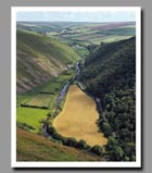 A small stream flows through the green hills of the Doone Valley of Devon, England.