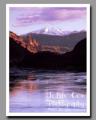 The Fisher Towers reflect in the Colorado River in Utah.