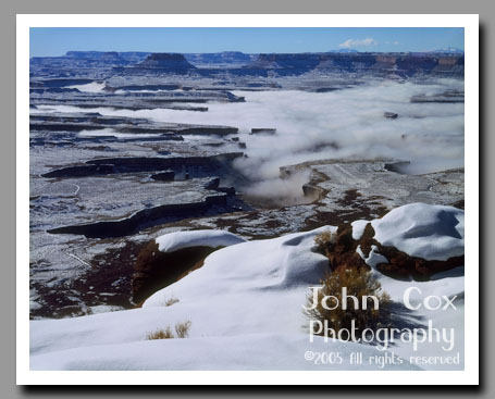 Low clouds fill the canyons of the green River below the Green River Overlook in Canyonlands National Park, Utah.