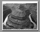 Washer woman arch can be seen in the distant spires below Mesa Arch from Canyonlands National Park in Utah.