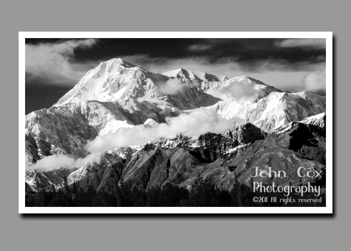 Clouds hover near a snow-dusted Denali in Denali National Park in Alaska.