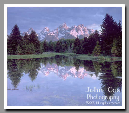 The Grand Tetons reflect in the crystalline waters of a small pond in Grand Teton National Park, Wyoming.