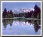 The Grand Tetons reflect in the crystalline waters of a small pond in Grand Teton National Park, Wyoming.