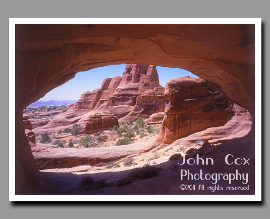 A sandstone landscape viewed through Tower Arch in Arches National Park, Utah.