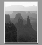 Washer woman arch can be seen in the distant spires below Mesa Arch from Canyonlands National Park in Utah.