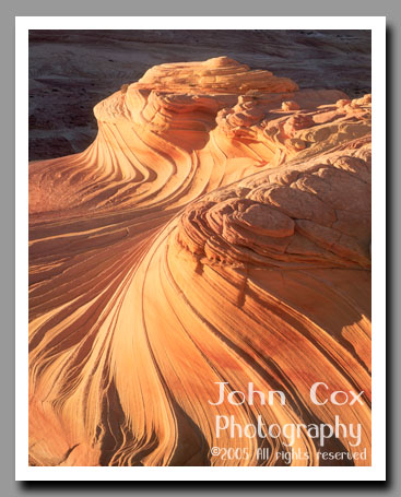 A sandstone wave glows brilliantly in the light of a setting sun in Coyote Buttes on the Utah-Arizona border.